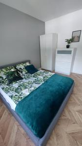 a bedroom with a large bed with a green blanket at Apartament Królewiecka 22 Centrum Molo jezioro Czos in Mrągowo