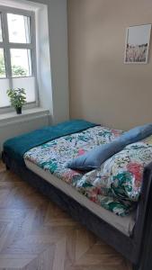 a bed in a bedroom with a comforter on it at Apartament Królewiecka 22 Centrum Molo jezioro Czos in Mrągowo