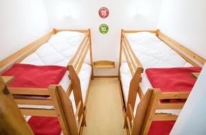 two bunk beds in a small room with red sheets at Les Balcons PROCHE PARC NATIONAL VANOISE appartements 2 pieces 8 pers in Termignon