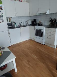 Shared apartment, Down Town Oslo, Osterhaus'gate 10 في أوسلو: مطبخ بأدوات بيضاء وأرضية خشبية