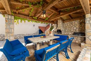 un patio con sillas azules y techo de madera en Villa O'Lucky, en Polje