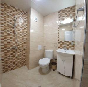 a bathroom with a toilet and a sink and a shower at Къща за гости - Пролет in Lozenets +6 photos