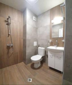 a bathroom with a toilet and a sink and a shower at Къща за гости - Пролет in Lozenets