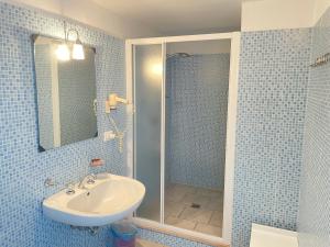a blue tiled bathroom with a sink and a shower at GALLIPOLI DUESTANZE in Gallipoli