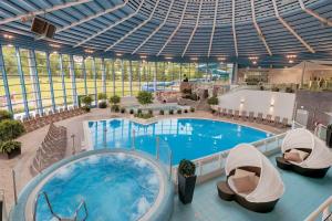 une piscine intérieure avec un bain à remous dans un bâtiment dans l'établissement Ferienhaus Nr 1 Sporthotel Oberhof, à Oberhof