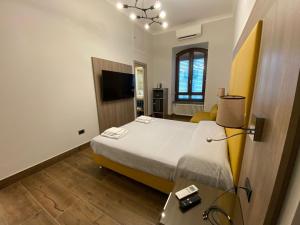 ein Schlafzimmer mit einem Bett und einem TV in der Unterkunft I MITI DI PARTENOPE in Neapel
