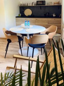 a table and chairs in a room with a plant at Willa Liliowa in Dębki