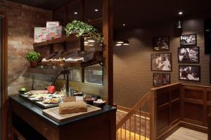 a restaurant with a counter with food on it at Bergen Harbour Hotel, WorldHotels Crafted in Bergen