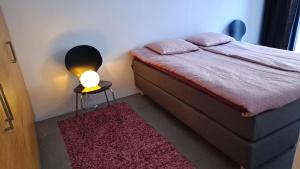 a bedroom with a bed with a lamp on a table at Uusi, avara, saunallinen keskustakaksio in Tampere