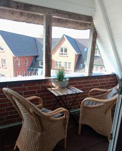 a screened in porch with two chairs and a table at MeerMomente in Dorum Neufeld