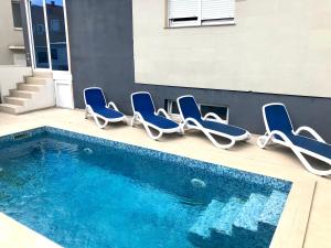 a group of chairs sitting next to a swimming pool at Vip Villa Tina in Novalja