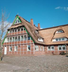 a large red brick building with a roof at MeerMomente in Dorum-Neufeld