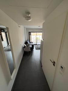 um corredor com um quarto com uma mesa e um espelho em Appartement tout équipé centre ville Menton em Menton