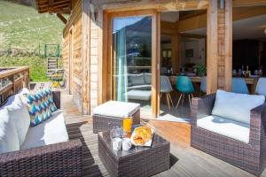 a patio with wicker chairs and tables on a deck at Chalet Levant Blanc - OVO Network in Seytroux