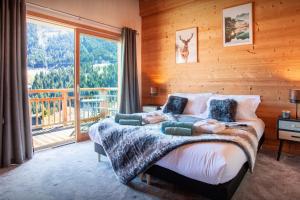 a bedroom with a bed and a large window at Chalet Levant Blanc - OVO Network in Seytroux