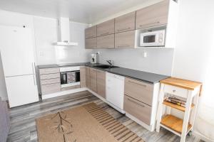 Una cocina con gabinetes blancos y un horno de estufa. en Villa Saananjuuri, en Kilpisjärvi