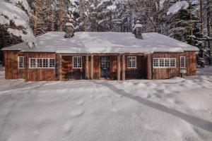 una cabaña de troncos con nieve en el techo en The Queen's Hut, en Aboyne