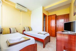 a hotel room with two beds and a tv at Villa Swiss in Ohrid