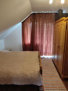 a bedroom with a bed and a red curtain at Casa Irilen in Mănăstirea Humorului