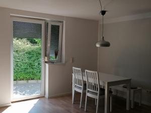 a dining room with a table and chairs and a window at Ferienwohnung Auengrund in Grub am Forst