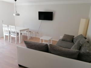 a living room with a couch and a table with chairs at Ferienwohnung Auengrund in Grub am Forst