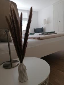 a vase on a table in a bedroom with a bed at Ferienwohnung Auengrund in Grub am Forst