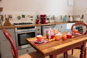 a kitchen with a wooden table with dishes on it at THE HYDE- secret hide away, near the beach. in Truro