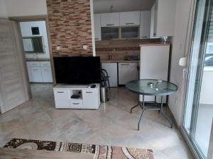 a kitchen with a table and a tv on a counter at Villa Elina Ulcinj Montenegro in Donji Štoj