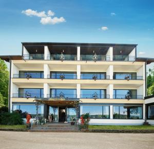 a large white building with people on the balcony at Vintage Hotel Petrisberg in Trier