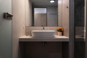 a bathroom with a white sink and a mirror at Dimitra Central Apts in Chania Town