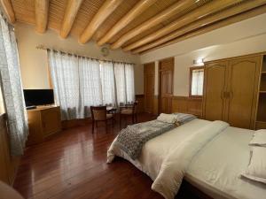 a bedroom with a bed and a table in it at New Royal Guest House in Leh