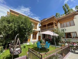 a house with chairs and a table in the yard at New Royal Guest House in Leh