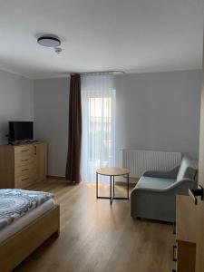 a bedroom with a bed and a couch and a table at Fajne Apartamenty in Karwia