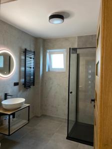 a bathroom with a sink and a glass shower at Fajne Apartamenty in Karwia
