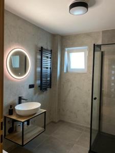 a bathroom with a sink and a mirror at Fajne Apartamenty in Karwia
