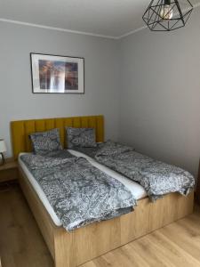 a bedroom with a bed with a wooden headboard at Fajne Apartamenty in Karwia