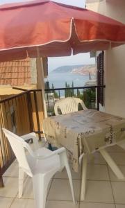 a table and chairs on a balcony with a view of the ocean at Guest house Ruzica in Sutomore