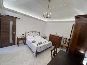 a bedroom with a bed and a table and a dresser at [Appartamento Centro Storico] Da nonna Maria ☆☆☆☆☆ in Procida