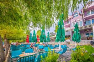a group of tables and chairs with umbrellas at Villa Swiss in Ohrid