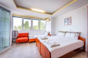 a bedroom with a bed and a couch and a chair at Villa Swiss in Ohrid