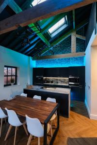 a kitchen with a wooden table and white chairs at The Eden Warehouse - Green Apartment, sleeps 5 in Southport