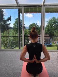 a woman is practicing yoga in front of a window at Domeček u Marcelky in Ruprechtice