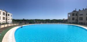 a large blue swimming pool next to two buildings at Appartamento Ca Vio Beach & Venice in Cavallino-Treporti