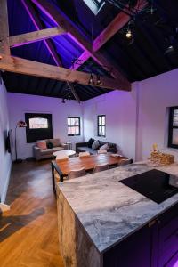 a living room with a wooden table and purple ceilings at The Eden Warehouse - Green Apartment, sleeps 5 in Southport