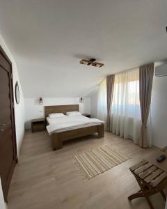 um quarto branco com uma cama e uma janela em Vila San Nicoara em Curtea de Argeş