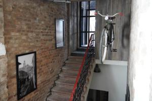 un escalier avec un vélo suspendu sur un mur de briques dans l'établissement Apartamenty Rymanów, à Rymanów