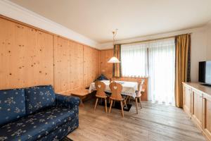 - un salon avec un canapé et une table dans l'établissement Residence Cesa Rives, à Selva di Val Gardena