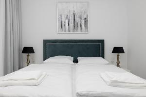 sypialnia z białym łóżkiem z 2 lampami w obiekcie Apartament DIAMOND w Kołobrzegu