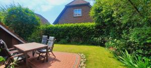 a patio with a table and chairs and a house at Ferienhaus Hooksiel in Hooksiel