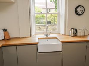 eine Küche mit Spüle und Fenster in der Unterkunft Snowdrop Cottage in Scarborough + 34 Fotos